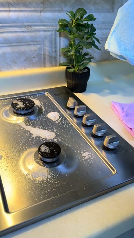 Creator cleaning a kitchen surface with Jif spray